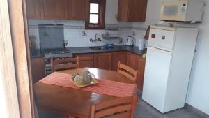 a kitchen with a wooden table and a white refrigerator at Montelife in Montevideo