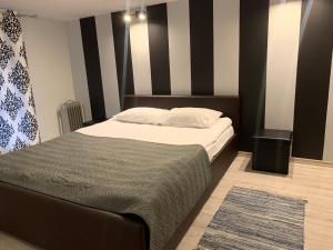 um quarto com uma cama e uma parede listrada a preto e branco em Modern-style flat 2 em Riga
