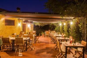 uma área de refeições exterior com mesas e cadeiras à noite em Relais Poggio Borgoni em San Casciano in Val di Pesa