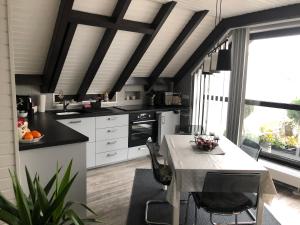 a kitchen with white cabinets and a table with chairs at Apartment Elegance in Höheischweiler