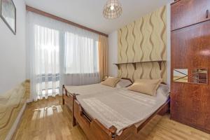 a bedroom with a bed and a large window at Lawendowy Zakątek - przytulne pokoje i pyszne śniadania in Łeba