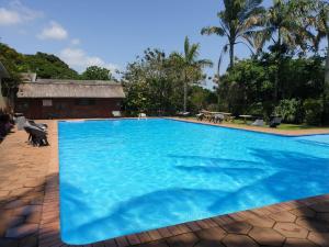 a large blue swimming pool in a resort at 23 Manzini Chalets-Pumba's Den in St Lucia