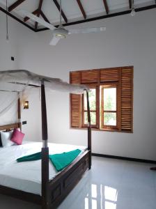 a bedroom with a bed and a window at Dolphin Cottage Mirissa in Mirissa