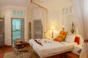 a bedroom with a large bed with flowers on it at The Maji Beach Boutique Hotel in Diani Beach