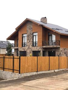 een huis met een houten hek ervoor bij Bakuriani Cozy Villa #4 in Bakuriani