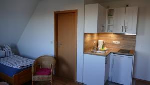 a small kitchen with a sink and a bed at Ferienwohnung 2, Neuendorf - Hiddensee in Neuendorf