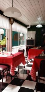 un comedor con 2 mesas y sillas rojas en Hotel Español en San Fernando