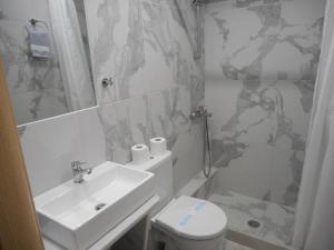 une salle de bain blanche avec un lavabo et des toilettes dans l'établissement Anatoli, à Agía Pelagía 93 autres photos