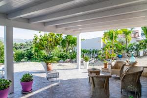 une terrasse avec des chaises en osier et une table. dans l'établissement Villa Montalbano, à Villaggio Mosè
