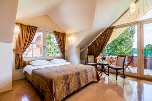 een slaapkamer met een bed en een groot raam bij Villa Avirio Vingis in Druskininkai