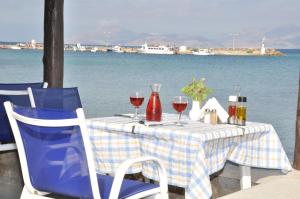 a table with two chairs and wine glasses at Mastichari Bay Hotel in Mastihari