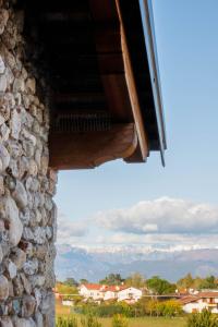 une fenêtre d'un bâtiment en pierre avec des montagnes en arrière-plan dans l'établissement Casanova Inn, à Martignacco