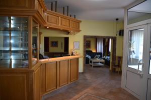 a kitchen with wooden cabinets and a living room at Hotel zum Gesundbrunnen in Bad Zwischenahn