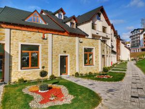 a brick house with a garden in front of it at Apartman Pahulja - Milmari in Kopaonik