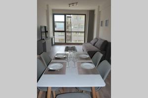 ein Wohnzimmer mit einem weißen Tisch und einem Sofa in der Unterkunft Brc Apartment in San Carlos de Bariloche