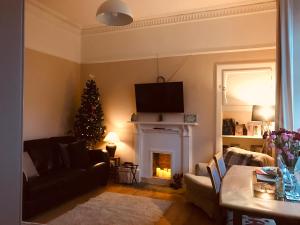 ein Wohnzimmer mit einem Weihnachtsbaum und einem Kamin in der Unterkunft A Wee Cottage In Dunfermline in Dunfermline