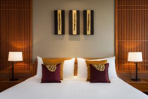 a bedroom with a bed with pillows and two lamps at Amari Don Muang Airport Bangkok in Bangkok
