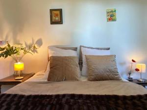 a bedroom with a bed with white sheets and pillows at Mirabelle, parking privé clos, petit déjeuner, enfants et animaux bienvenus in Chieulles