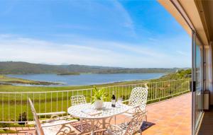 a patio with a table and chairs and a view of a lake at Wilderness Lake View Self-Catering in Wilderness