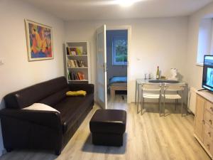 a living room with a black couch and a table at Apartamenty Parkowa in Koszalin