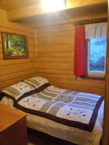 małe łóżko w pokoju z oknem w obiekcie Domek Na Skarpie w mieście Zubrzyca Dolna