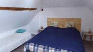 um quarto com 2 camas e um cobertor azul em Le Gros Tilleul em Chepoix