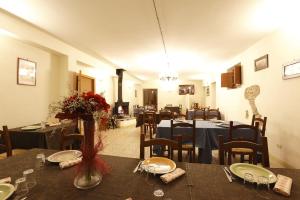 a dining room with tables and chairs and a fireplace at Godere Agricolo in Penna Alta