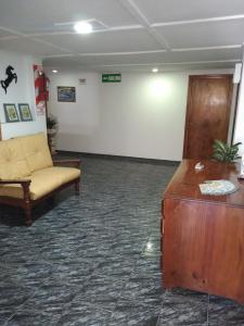 een wachtkamer met een bank en een tafel bij Hotel Central park in Santa Clara del Mar