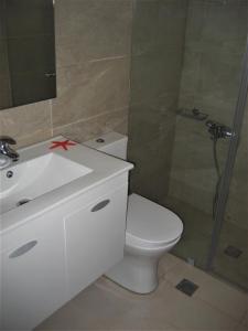 a bathroom with a toilet and a sink and a shower at Corina Apartments in Sitia
