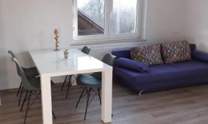 - un salon avec une table blanche et un canapé bleu dans l'établissement Apartmaji Pika, à Cerklje na Gorenjskem