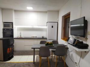 a kitchen with a table and chairs and a refrigerator at House Sarajevo in Sarajevo