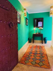 Habitación con puerta roja y pared verde en Riad Dar Balthazar, en Marrakech