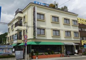 a large yellow building with a sign in front of it at kawagutiko station inn / Vacation STAY 63733 in Azagawa