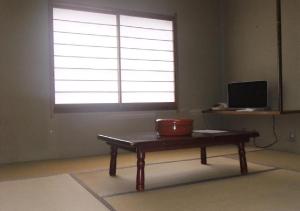 um quarto com uma mesa em frente a uma janela em kawagutiko station inn / Vacation STAY 63722 em Azagawa