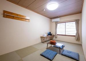 een woonkamer met een tafel en een raam bij kawagutiko station inn / Vacation STAY 63732 in Azagawa