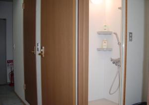 a bathroom with a wooden door and a sink at kawagutiko station inn / Vacation STAY 63732 in Azagawa