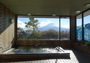 a bathroom with a view of a mountain through a window at kawagutiko station inn / Vacation STAY 63732 in Azagawa