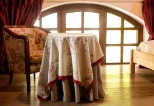 uma mesa com uma toalha de mesa ao lado de duas cadeiras em Hotel Edelhof em Tarvisio