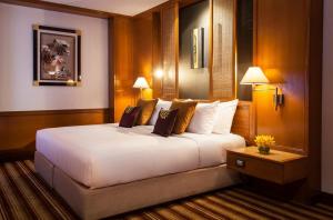a hotel room with a large white bed and two lamps at Amari Don Muang Airport Bangkok in Bangkok
