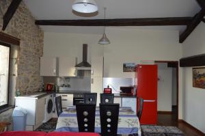 uma cozinha com uma mesa e um frigorífico vermelho em L'apartement deluxe em Azille