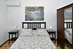 a bedroom with a bed and two nightstands and a painting at FINCA VILLA MARINA in Málaga +37 photos