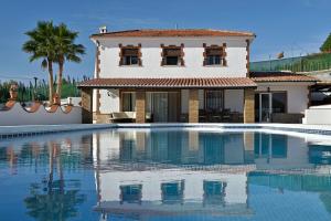 a villa with a swimming pool in front of a house at FINCA VILLA MARINA in Málaga