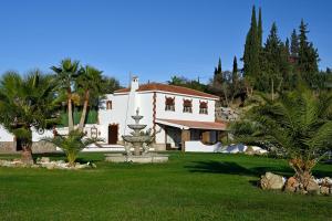 a large white house with a fountain in the yard at FINCA VILLA MARINA in Málaga