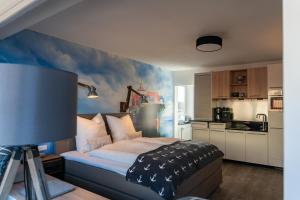 a bedroom with a bed and a kitchen at Heimathafen in Cuxhaven