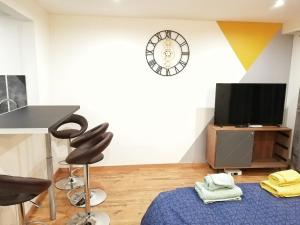 a living room with a table and a clock on the wall at LUCKY PLACE - PARKING - CENTRE - BALCON in Colmar