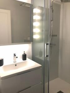 a white bathroom with a sink and a shower at Appart 2 pièces avec parking QUARTIER DU LAC in Saint-Jean-de-Luz +27 photos