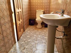 a bathroom with a sink and a toilet at Scorpion Hill Lodge in Busua +45 photos