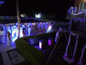 um grupo de pessoas em torno de uma cerimônia de casamento à noite em Hotel Villa Amparo em Chinauta
