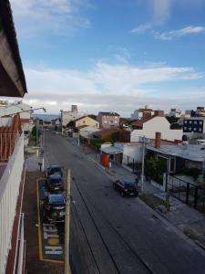 una calle de la ciudad con coches aparcados en la carretera en Lo de Carlos en Santa Teresita