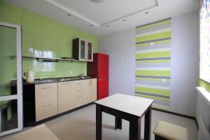 cocina con mesa y pared roja y verde en Guest House on Vokzalnaya, en Nyandoma